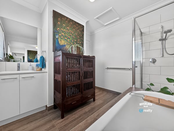 Contemporary bathroom featuring modern fixtures, natural light, and a unique wooden cabinet for added storage.