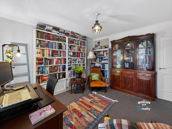 Cozy reading nook with expansive bookshelves and a versatile workspace, perfect for relaxation and productivity.