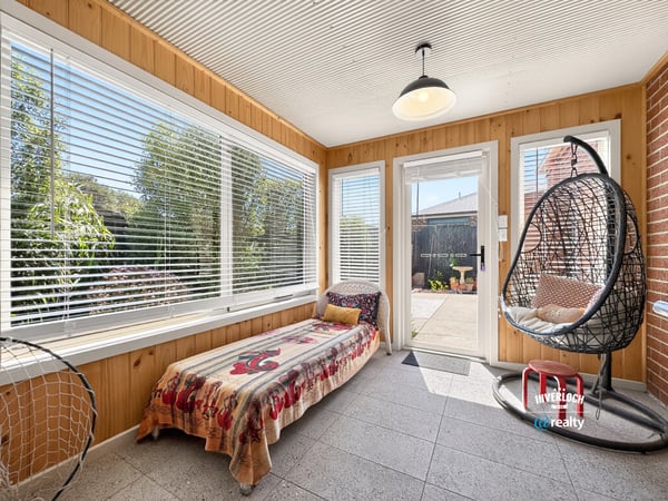 Bright and inviting sunroom features large windows, perfect for relaxing or enjoying morning coffee.