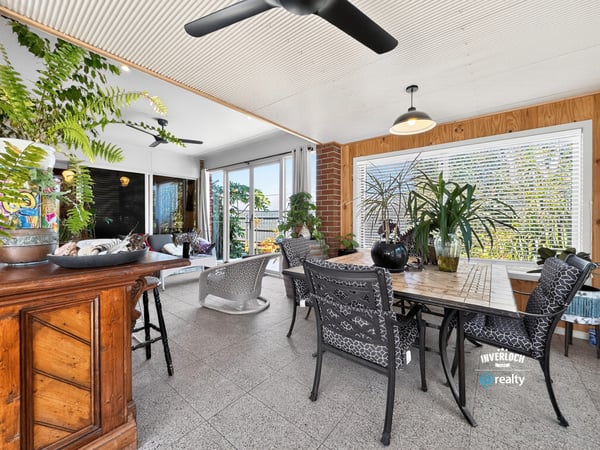 Bright and airy sunroom featuring ample greenery and spacious dining area for leisurely gatherings.