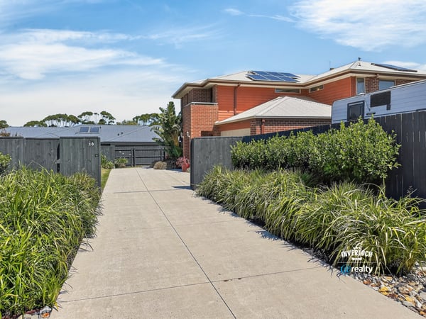 This property features a spacious driveway surrounded by well-maintained landscaping, leading to a modern home.