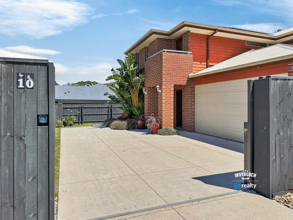 Modern home with a spacious driveway, vibrant landscaping, and convenient access to outdoor amenities.
