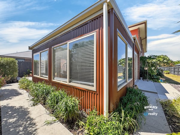 This contemporary home features expansive windows, inviting natural light and showcasing the surrounding greenery.