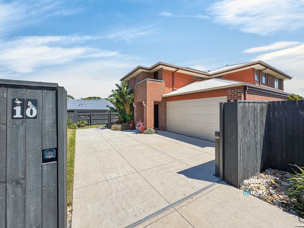 Spacious home with modern features, featuring a large driveway and well-maintained landscaping, perfect for family living.