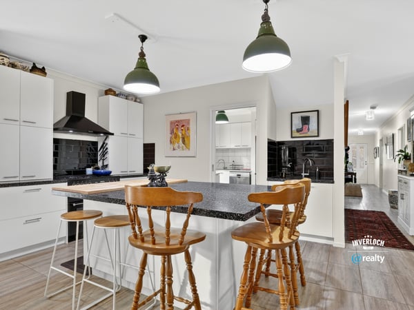 Modern kitchen featuring a spacious island, sleek cabinetry, and ample natural light flowing throughout the open layout.