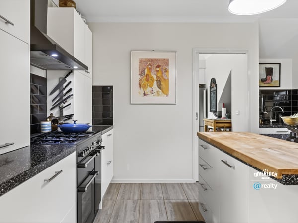 Modern kitchen featuring sleek appliances, ample counter space, and distinct artwork for a vibrant touch.