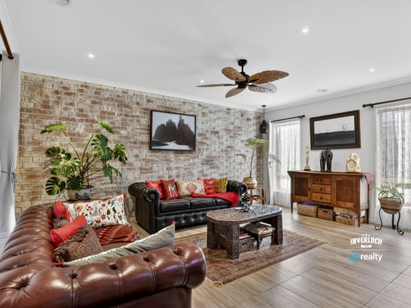 Discover a unique living space featuring exposed brick, vibrant textiles, and natural light, perfect for relaxation.
