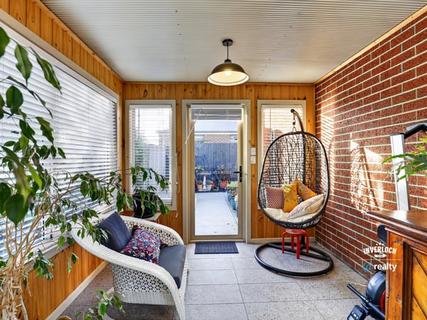 Bright sunroom featuring a cozy seating area and access to a beautifully landscaped outdoor space.