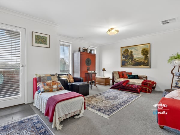Spacious living area features abundant natural light, unique decor elements, and cozy textiles perfect for gatherings.