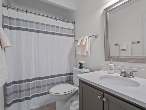 Updated primary bathroom with walk-in shower, granite countertop and new mirror