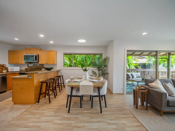 Modern open-concept kitchen and dining area, seamlessly connecting to a bright outdoor living space.