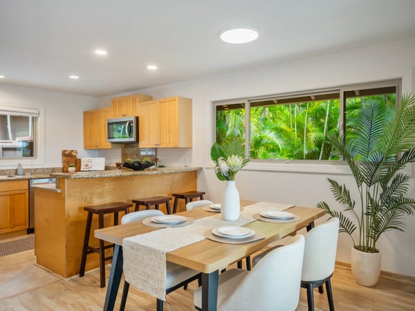 Bright, open kitchen and dining area seamlessly connect to lush outdoor views, perfect for entertaining.