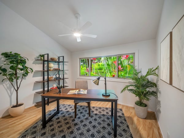 Bright home office featuring a large window, natural light, and vibrant views of lush greenery.