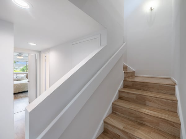 Bright, modern stairway leading to a spacious living area, showcasing open design and natural light.