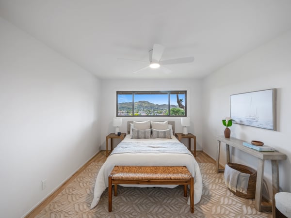 Bright bedroom featuring panoramic mountain views, modern furnishings, and natural light pouring in through large windows.