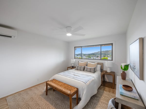 Bright and spacious bedroom featuring large windows with scenic views and modern furnishings for comfort.