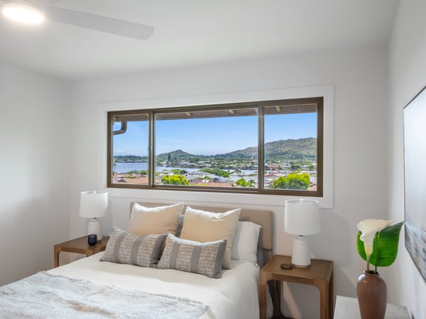 Bright bedroom featuring panoramic views of the waterfront and nearby hills, perfect for tranquil mornings.