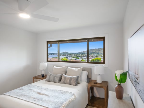 Bright bedroom featuring mountain views, modern decor, and large windows for ample natural light.