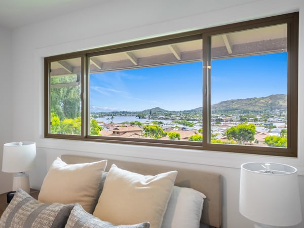 Bright bedroom featuring expansive windows that showcase stunning panoramic views of the surrounding landscape.