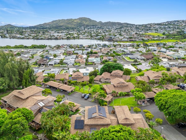 Stunning aerial view showcasing expansive waterfront and vibrant community nestled near picturesque mountain backdrops.