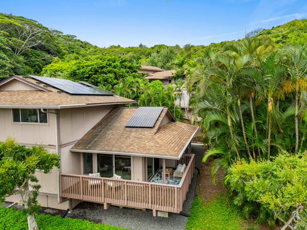 Discover this unique home surrounded by lush greenery, featuring solar panels and ample outdoor space.