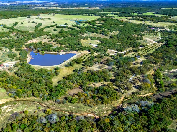 PROPERTY AERIAL...Exceptional 284 Acre Ranch With A Log Cabin, Lake, Ponds, Creeks, Pecan Orchard, Hay Meadow, Woods, And Outbuildings!