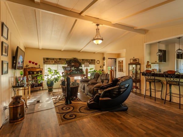LIVING ROOM WITH FRONT DOOR ENTRANCE IN THE BACKGROUND AND BEAUTIFUL CUSTOM BREAKFAST BAR TO THE RIGHT.