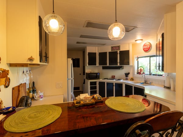 KITCHEN WITH BREAKFAST BAR IN FORGROUND.