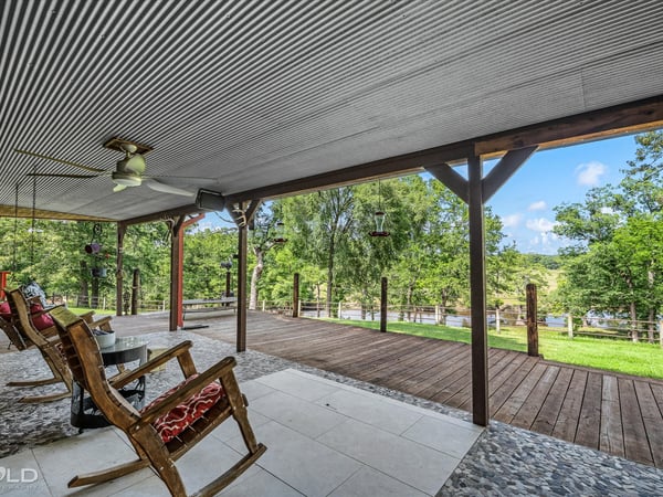 Spacious covered porch overlooking lush greenery, perfect for relaxation and outdoor gathering opportunities.