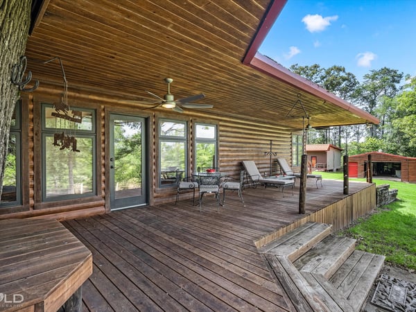 Spacious log home featuring a generous porch, ideal for outdoor living and relaxation surrounded by nature.