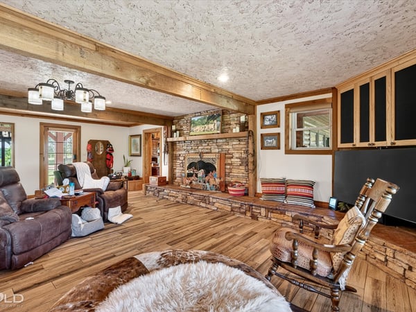 Discover a spacious living area featuring a unique stone fireplace and abundant natural light.