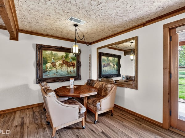 Cozy dining nook features natural light, unique artwork, and a welcoming atmosphere for intimate gatherings.