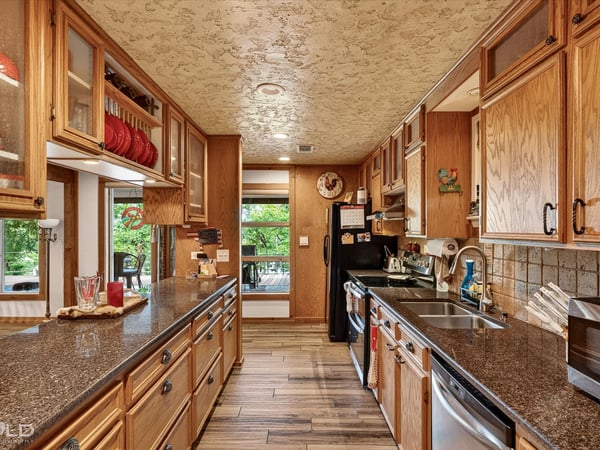 Spacious kitchen featuring ample cabinetry, granite countertops, and large windows that invite natural light.