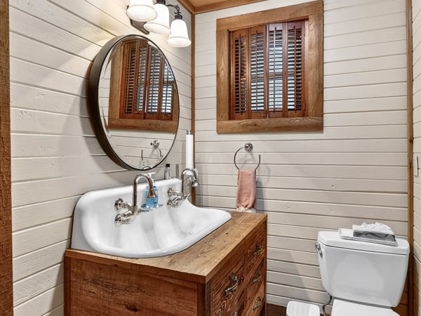 Cozy bathroom featuring a double sink vanity, natural wood accents, and soft lighting for a warm ambiance.
