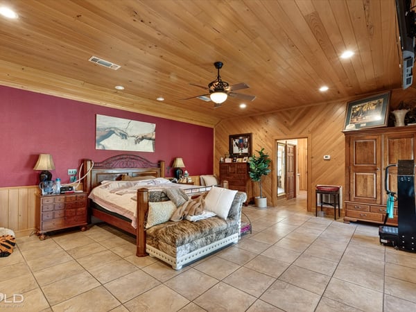 Spacious master bedroom featuring warm wood accents and ample natural light, perfect for relaxation and retreat.