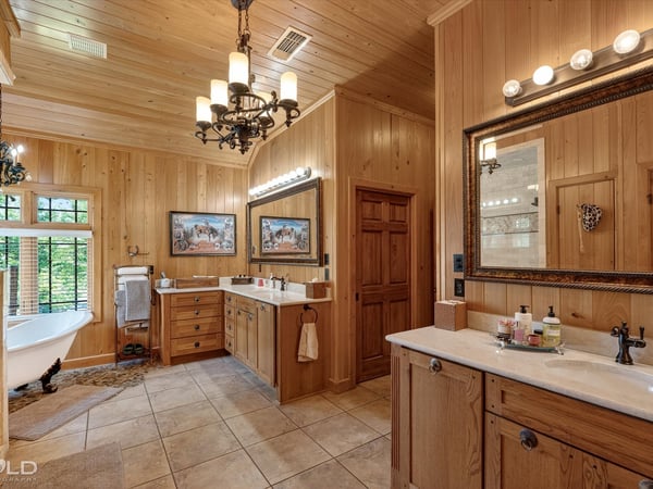 Spacious bathroom with natural wood accents, dual vanities, and a soaking tub for relaxation.