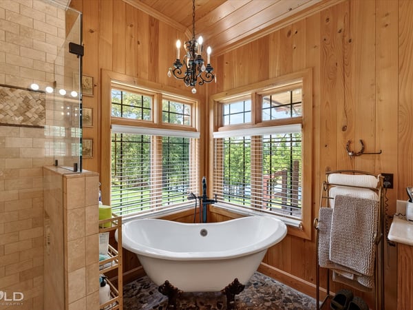 Experience a bright, inviting bathroom featuring a freestanding tub and large windows with scenic views.
