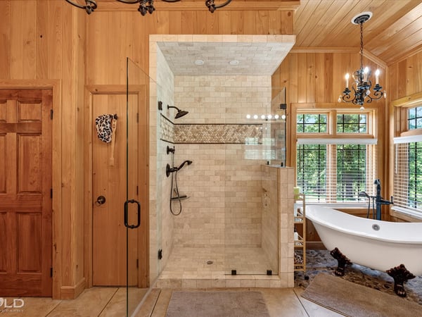 This luxurious bathroom features a spacious walk-in shower and a freestanding tub, surrounded by natural light.