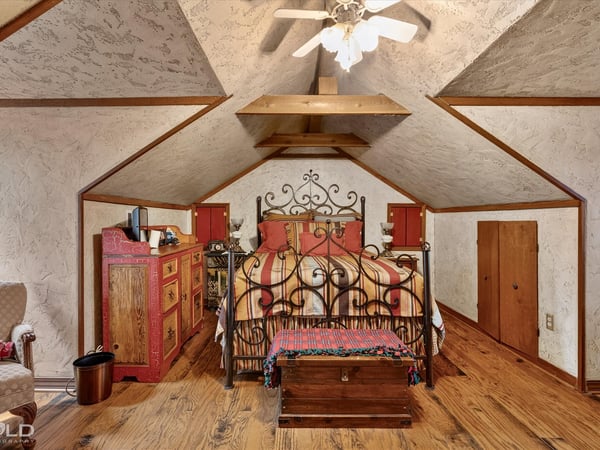 Cozy attic bedroom featuring unique architecture, rustic decor, and ample storage options for personal belongings.