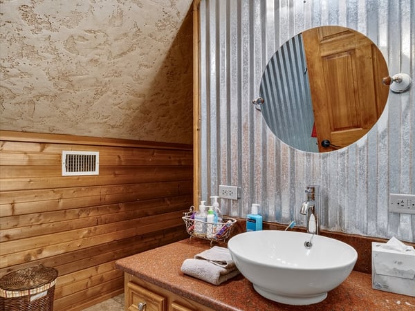 This unique bathroom features rustic wood accents and modern fixtures, creating a warm and inviting atmosphere.