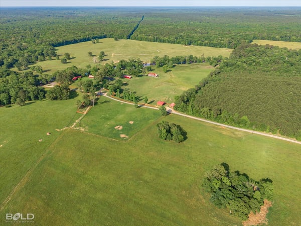 Expansive rural landscape featuring open fields, mixed woodlands, and potential for agricultural or recreational use.