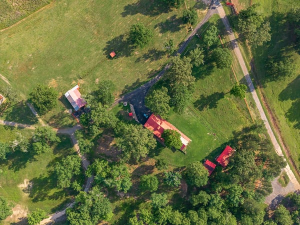 Discover a picturesque property featuring lush greenery, a winding river, and ample space for outdoor activities.
