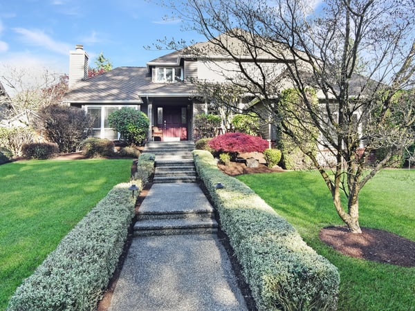Inviting home with a beautifully landscaped yard and welcoming entrance, perfect for gatherings and relaxation.