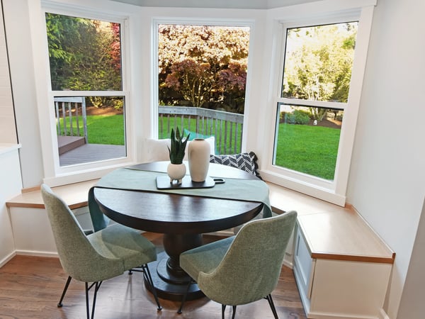 Sunny breakfast nook with large windows offering picturesque views of the lush backyard and garden.