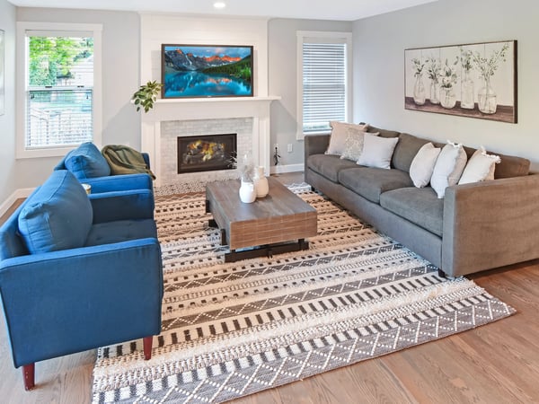 Bright and inviting living room featuring a cozy fireplace, and natural light.