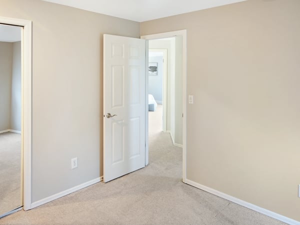 Upstairs find the 2nd bedroom next to the 3rd bedroom. Spacious room with soft carpeting, ideal for versatile living or office use.