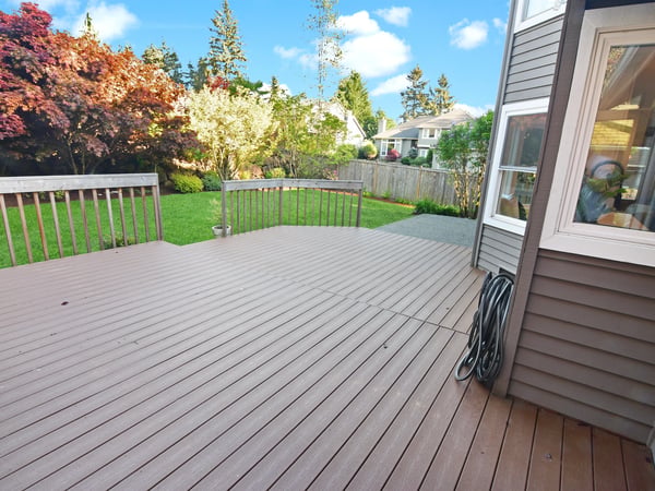 Spacious deck perfect for outdoor gatherings, surrounded by vibrant landscaping and lush greenery.