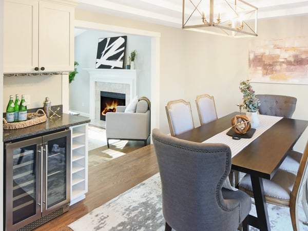 Bright dining area flows into a cozy living space, featuring modern finishes and an inviting fireplace.
