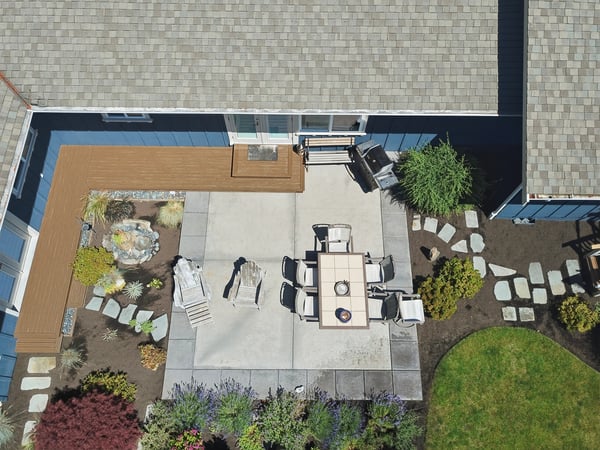 Spacious outdoor patio with dining area, surrounded by lush landscaping and thoughtful stone pathways.