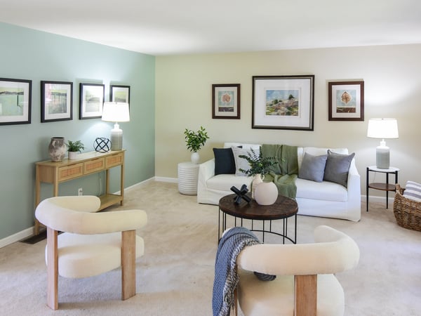 Bright and inviting living room featuring soft hues, ample natural light, and comfortable seating arrangements.